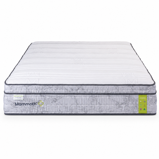 A Mammoth mattress shown from a high angle on a clean white background. The mattress features a white quilted top surface with subtle horizontal channel stitching, a gray patterned side bolster, and a small lime green label on the right side.