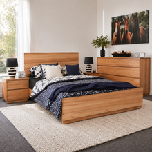 Load image into Gallery viewer, A modern bedroom set featuring a light oak wood bed frame, matching nightstands, and a six-drawer dresser, styled with navy and white patterned bedding on a textured cream rug.