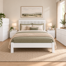 Load image into Gallery viewer, A white wooden bed frame with a slatted headboard, styled with sage green and beige bedding, set in a bright, modern bedroom with matching white nightstands, a white dresser, and a large woven rug.
