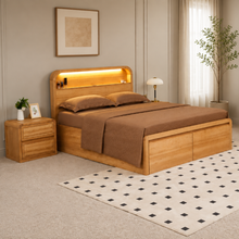 Load image into Gallery viewer, A modern wooden bed frame with an integrated headboard shelf and warm LED lighting, styled in a bedroom with brown bedding, a matching nightstand, and a patterned rug.