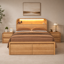 Load image into Gallery viewer, A light oak wood platform bed with a matching headboard and footboard, styled in a bedroom with brown bedding, two matching nightstands, and a warm LED light in the headboard niche.