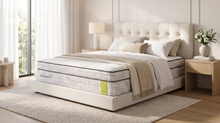 Load image into Gallery viewer, A luxury mattress shown on a bed in a modern, bright bedroom. The mattress has a white and gray quilted pattern with a small green brand tag on the side.